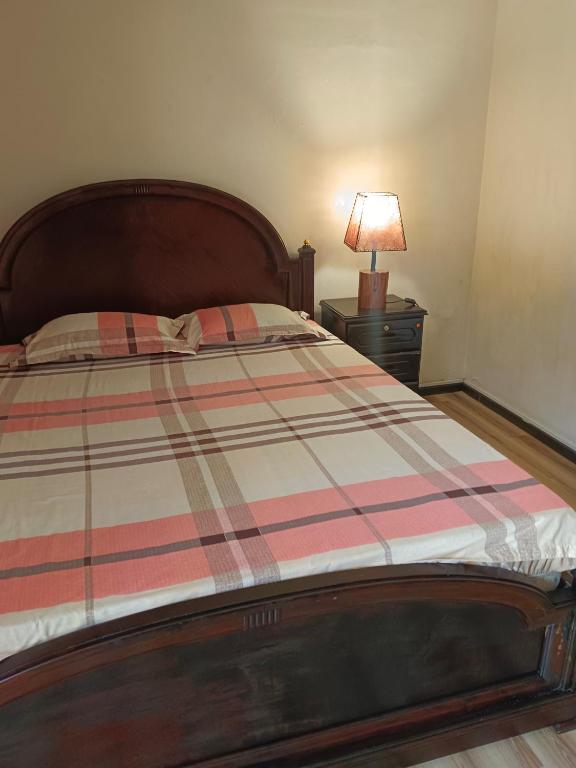 a bedroom with a bed and a lamp on a night stand at Albergue Happy Backpacker in Cuenca