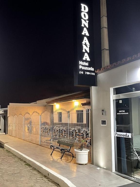a bench sitting outside of a building at night at Hotel Pousada Dona Ana in Aparecida