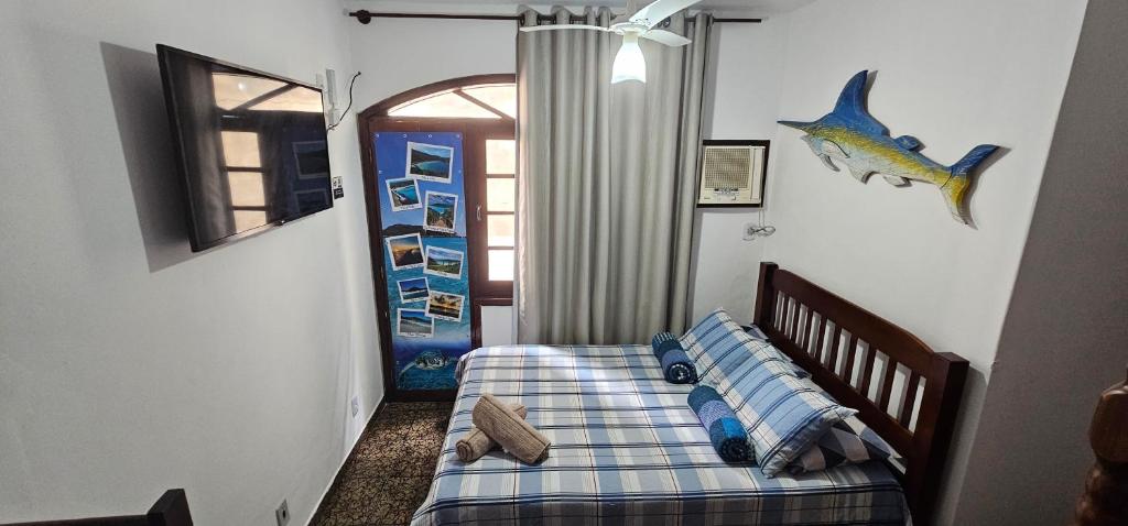 a bedroom with a bed with a fish on the wall at Suíte Trilha do Sol 2 in Arraial do Cabo