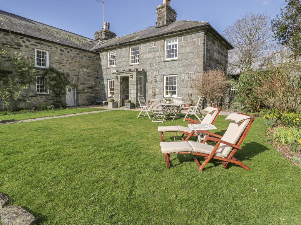 a group of chairs and a table in front of a house at Bwthyn Mawr in Harlech