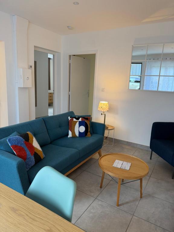 a living room with a blue couch and a table at La Belle Prise in Matougues