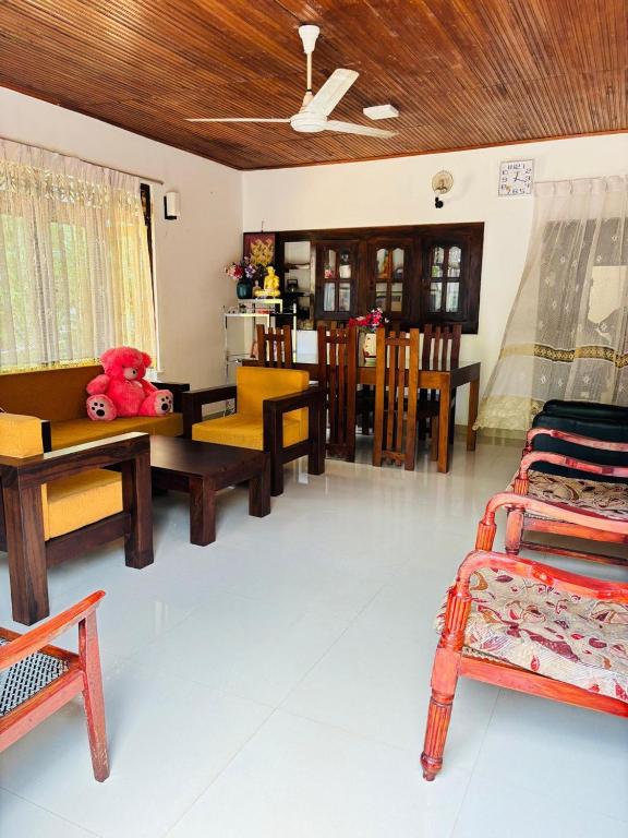 a living room with wooden furniture and a dining room at Nihal Villa in Weligama