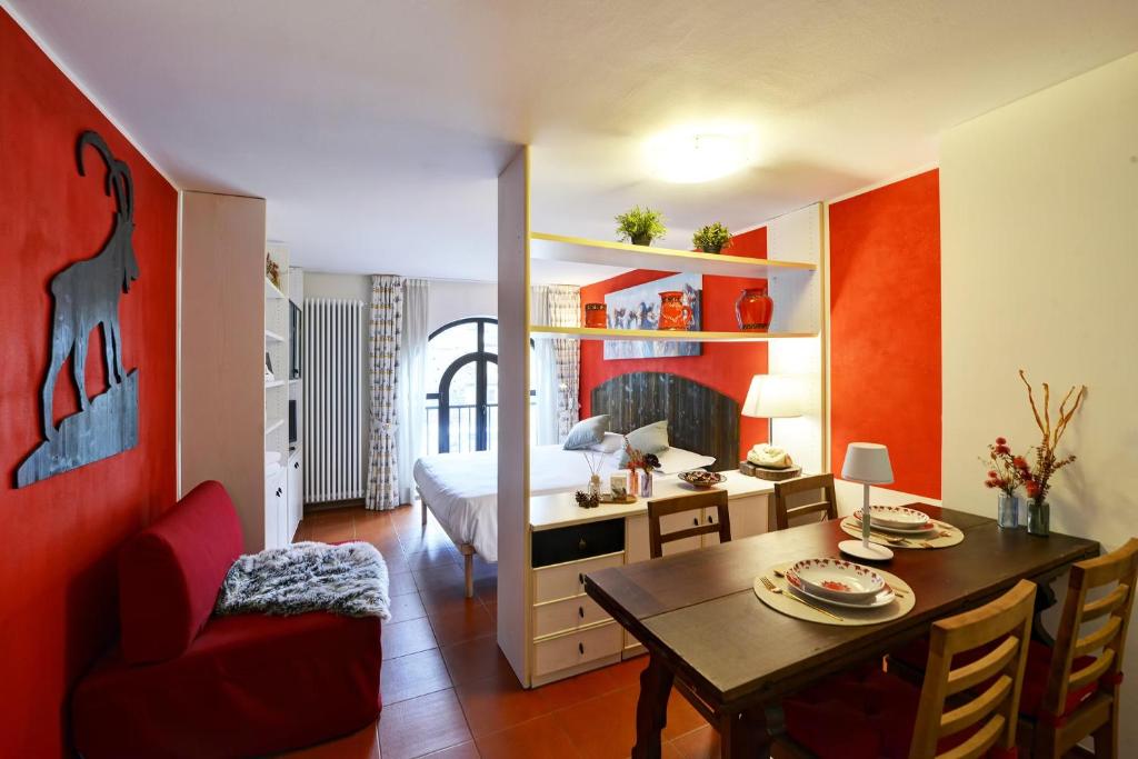a bedroom with a bed and a dining room with a table at Maison Clocher in Pré-Saint-Didier