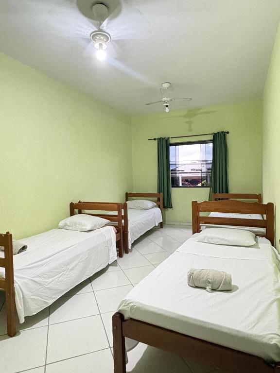 a room with two beds and a window at Hostel Costa Rio in Rio das Ostras