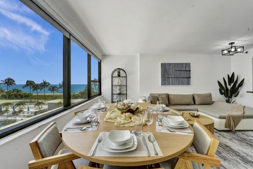a dining room with a table and chairs and a couch at Large Ocean View 2 BDR Condo Beachfront Hotel 504 in Miami Beach