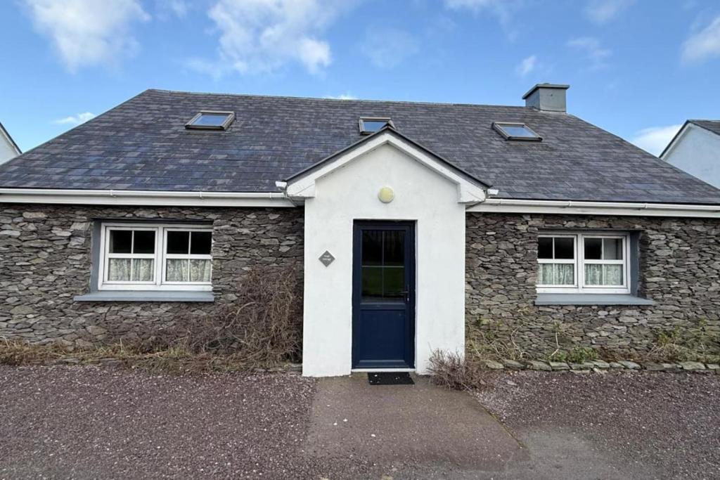 a brick house with a blue door and windows at Skellig Cottage - Portmagee in Lateeve