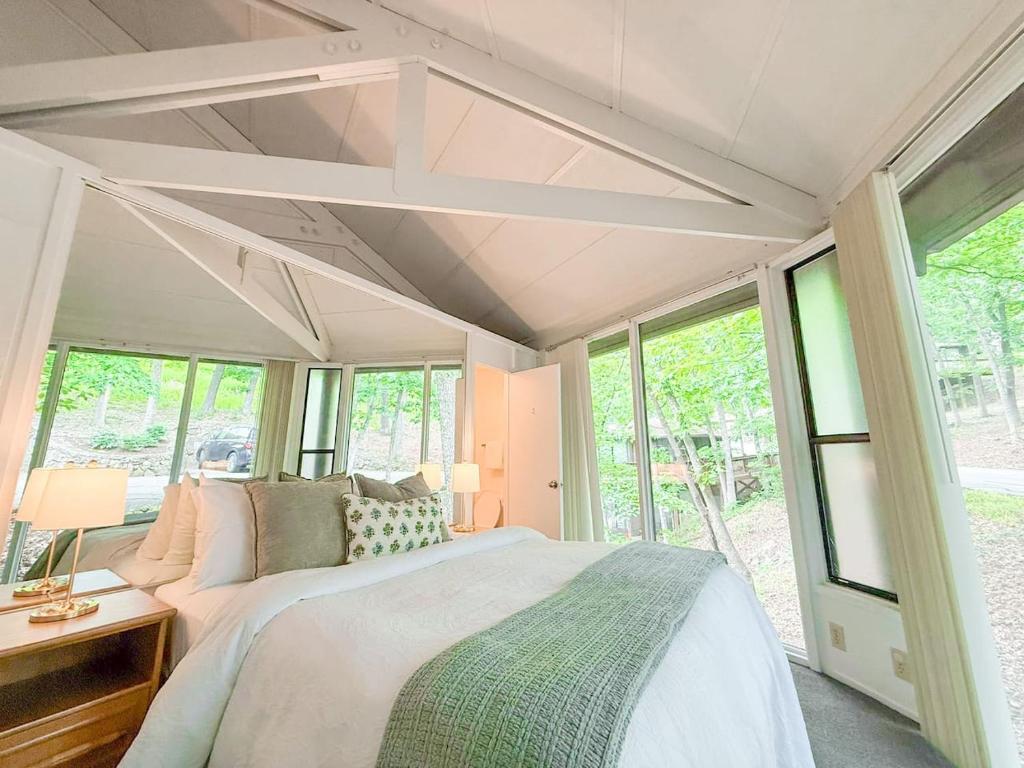 a bedroom with a large bed and windows at 10 Branch Bungalow Treetop in Four Seasons