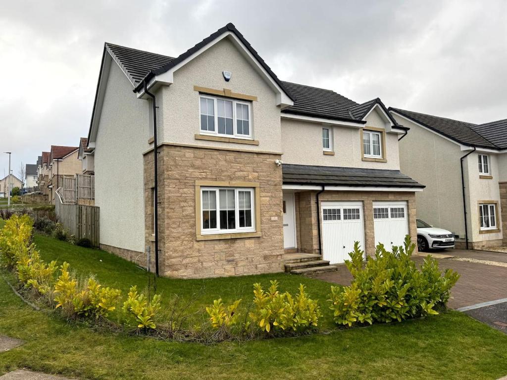 a house with a car parked in the driveway at Luxury 4BR Detached Exec Home in Cadzow