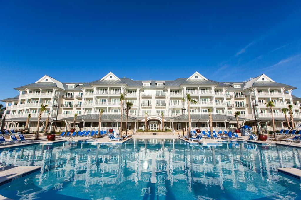 a hotel room with a pool and a large swimming pool at The Beach Club at Charleston Harbor Resort and Marina in Charleston