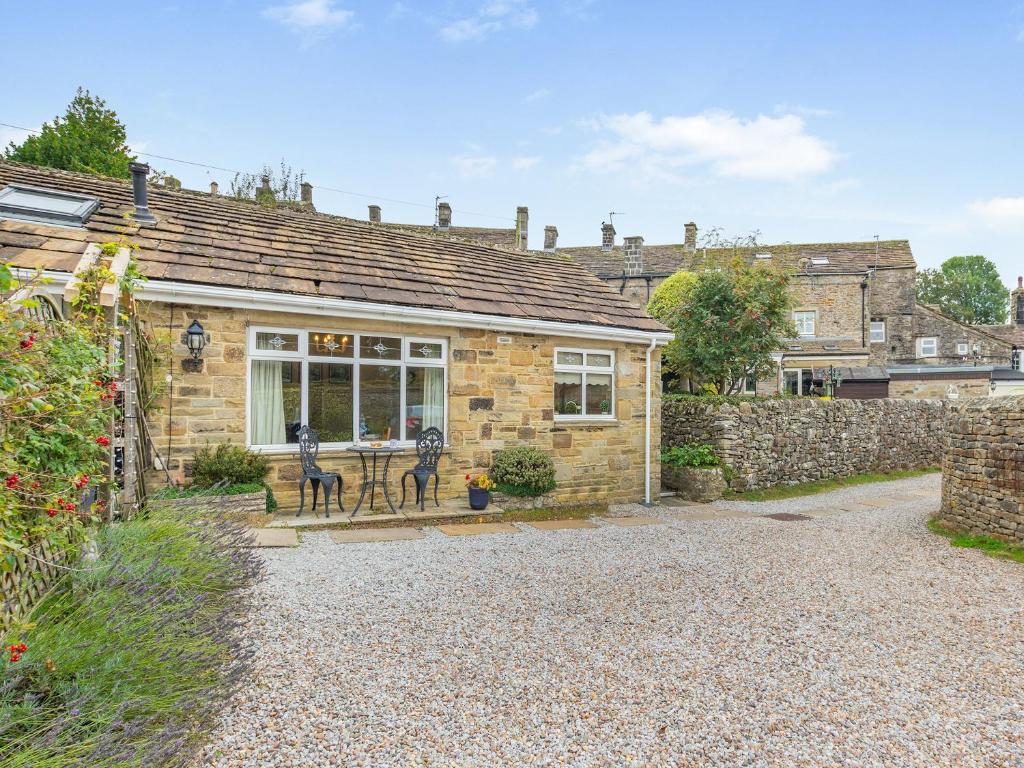 a stone house with a table in front of it at Polly's Fold in Grassington