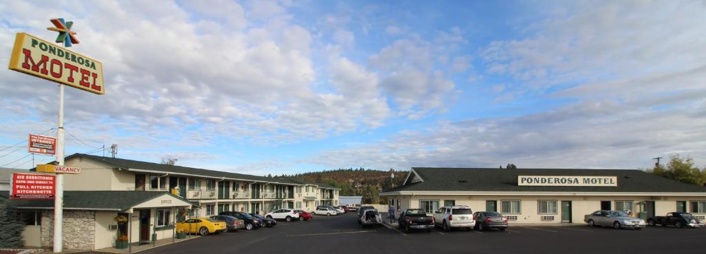 a motel with cars parked in a parking lot at Ponderosa Motel in Goldendale