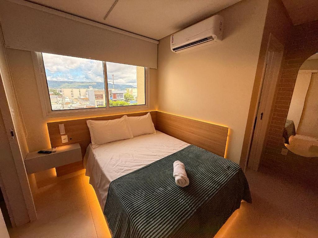 a small bedroom with a bed and a window at Apartamento com suíte e sala com ar-condicionado in Barreiras