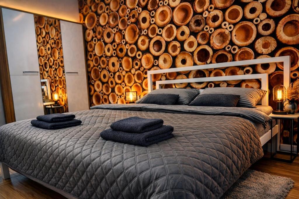 a bedroom with a large bed with a wall of logs at Kobylianska-Premium 2 Room in Chernivtsi