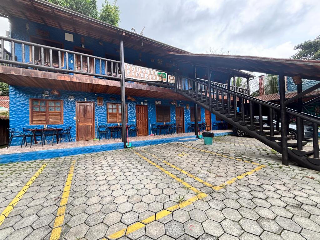 a train station with a blue building with a staircase at Pousada Figueira in Trindade