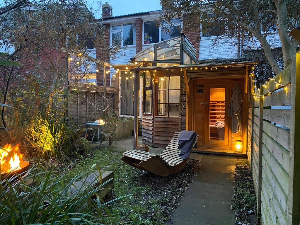 a tiny house in a garden with a bench at Cosy hideaway with garden sauna in Cambridge in Cambridge