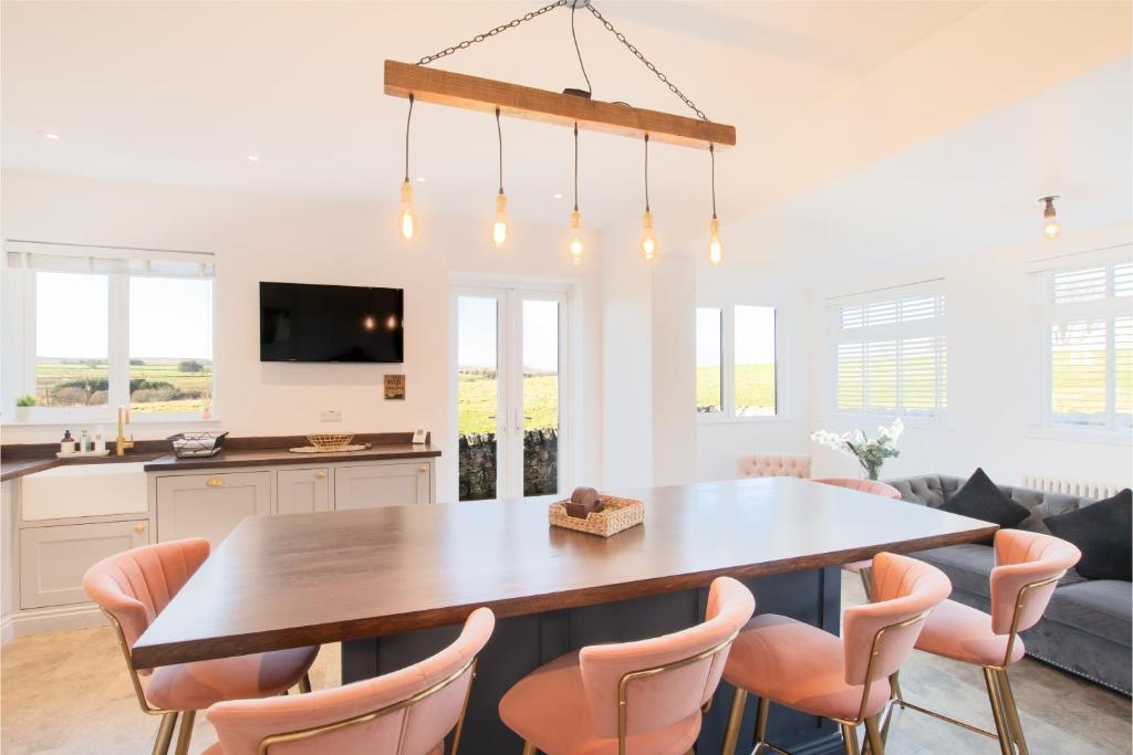 a kitchen and dining room with a wooden table and chairs at Northern Hideaways, Sunnyside, Otterburn in Otterburn