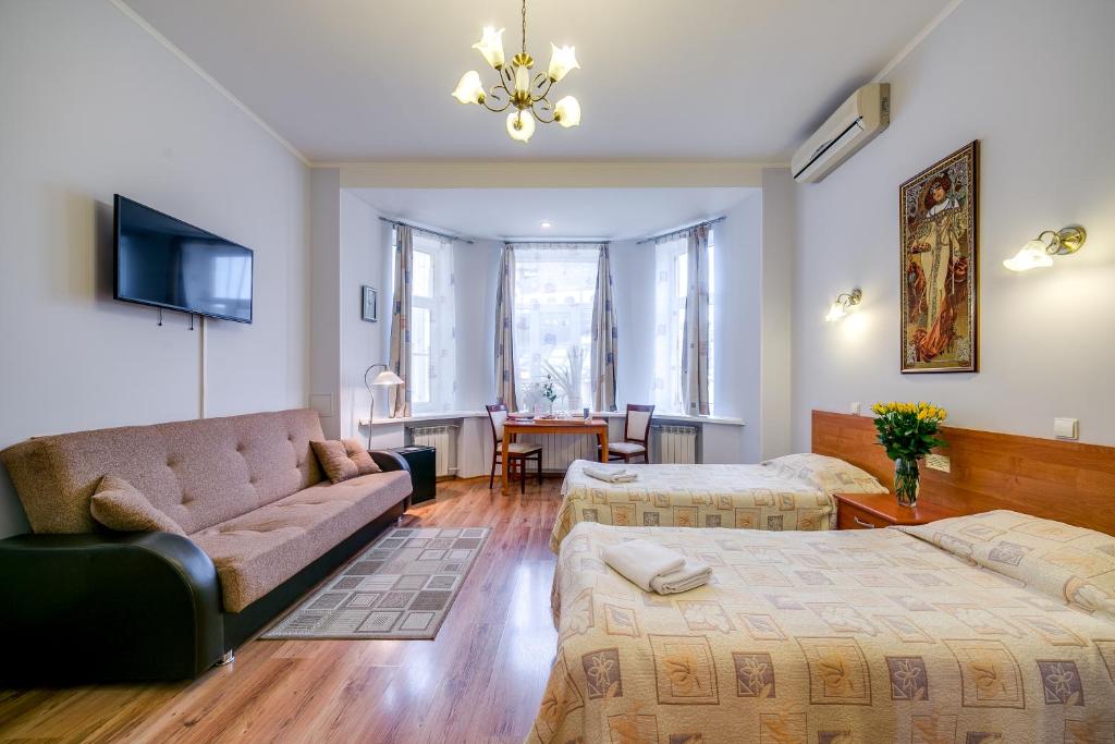 ein Wohnzimmer mit 2 Betten und einem Sofa in der Unterkunft Park Lane Inn in Sankt Petersburg