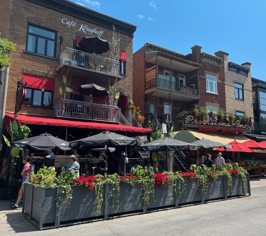 a restaurant with tables and umbrellas in front of a building at Petit Hôtel - Café Krieghoff in Quebec City