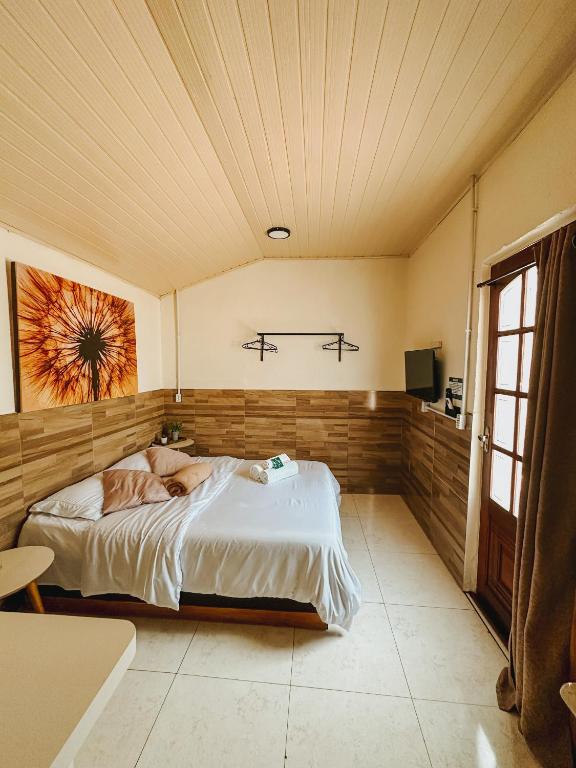 a bedroom with a large bed in a room at Espaços Cardoso, AURORA - luz e leveza in Igrejinha