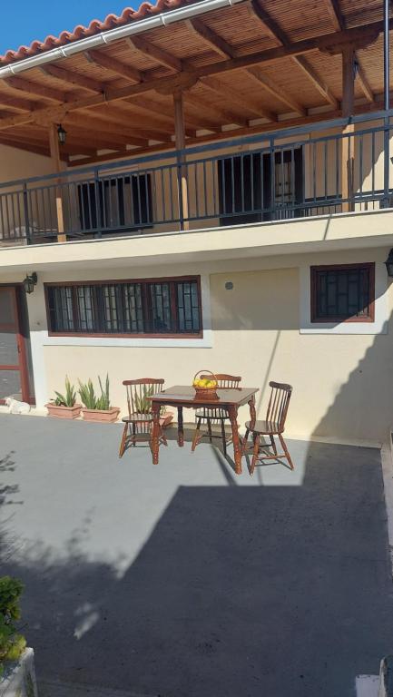 a patio with a table and chairs in front of a house at FAVIEROS-The secret Garden in Mesochórion