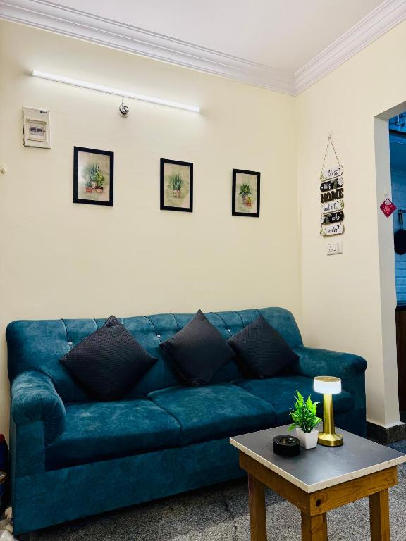 a blue couch in a living room with a table at Namma Suites 1BHK Serviced Apartment near NIMHANS & St Johns hospital in Bangalore