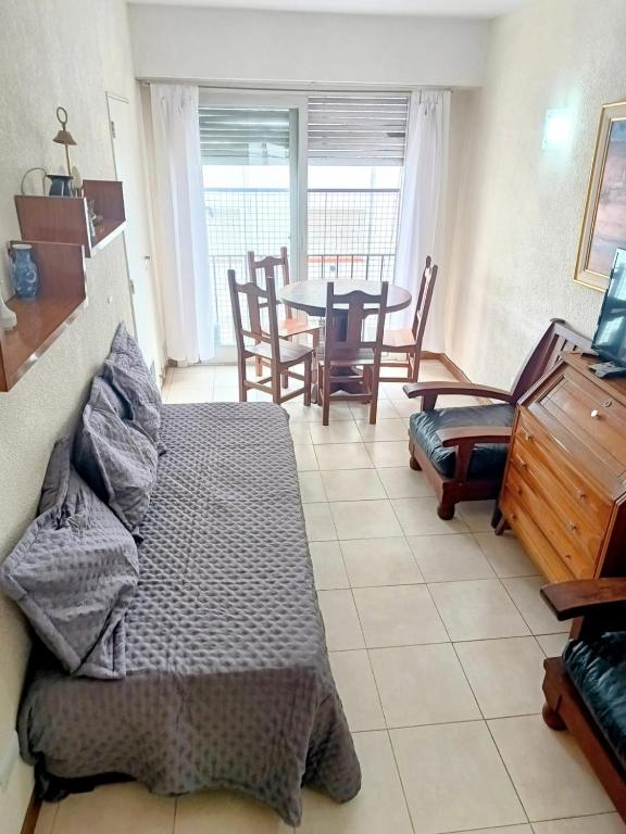 a bedroom with a bed and a table and chairs at Depto Avenida Colón-Mar del Plata in Mar del Plata