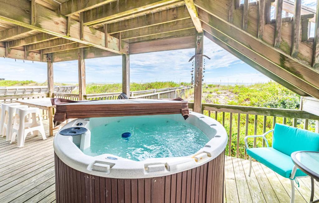 a hot tub on a deck with a table and chairs at Serendipity - KDH MP 6.5, Oceanfront, Amazing Ocean View, Hot Tub, Pets OK, YR Flex Stays in Kill Devil Hills