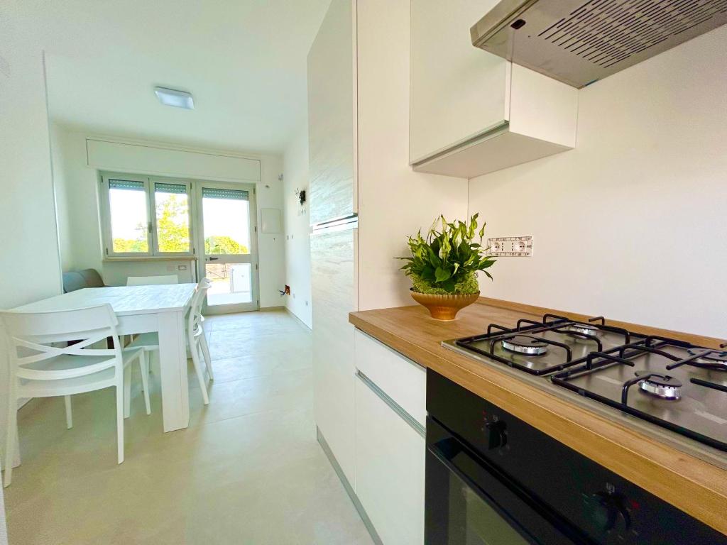 a kitchen with a stove and a table in it at Sea Apartment - Torre Pali in Torre Pali