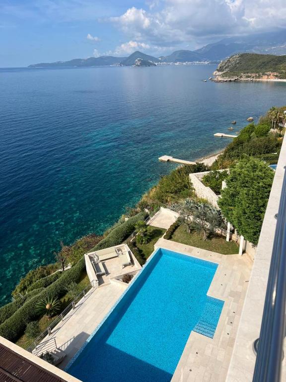an aerial view of a swimming pool next to the water at Luxury Seafront Villa Rezevici in Reževići