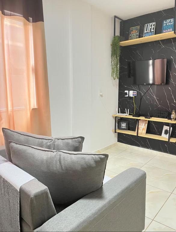 a living room with a gray couch and a shelf at Berenice Concept Residence - By Temporada Expert in Feira de Santana