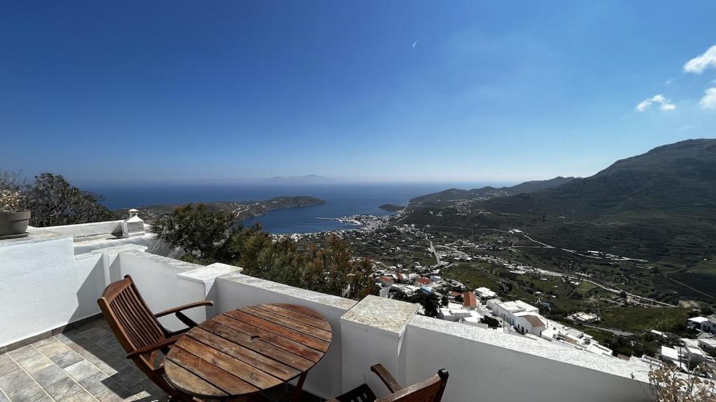 a table and chairs on a balcony with a view at Camaraki Capitano House , Chora Serifos in Serifos Chora