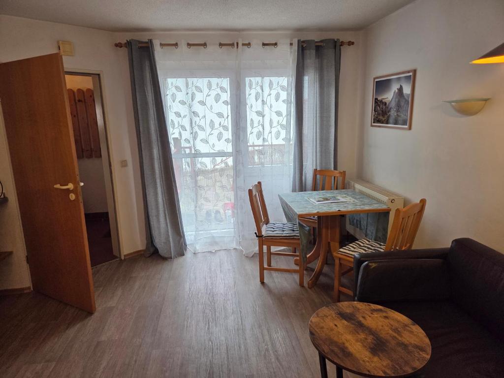 a living room with a table and a couch at Apartmentanlage am Kellerberg in Zandt