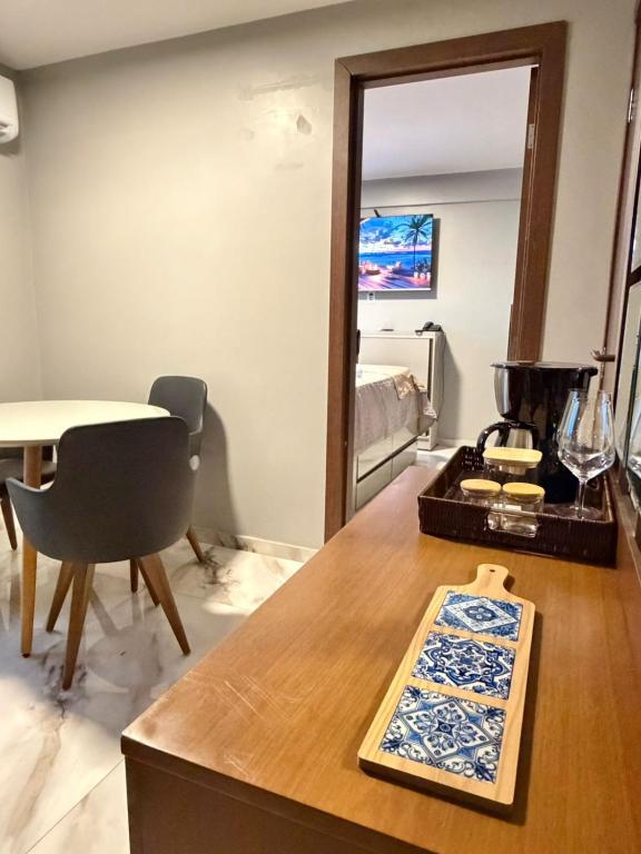 a living room with a table and a mirror at Estilo e Praticidade - Seu Flat ao lado do mar in São Luís