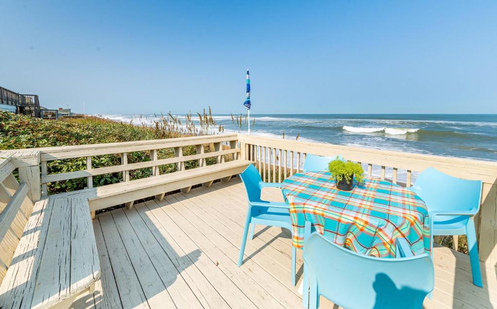 a table and chairs on a deck with the beach at Gypsea Rose - Southern Shores, Oceanfront, Ocean View, Hot Tub, Pets OK, Flex Stays in Southern Shores