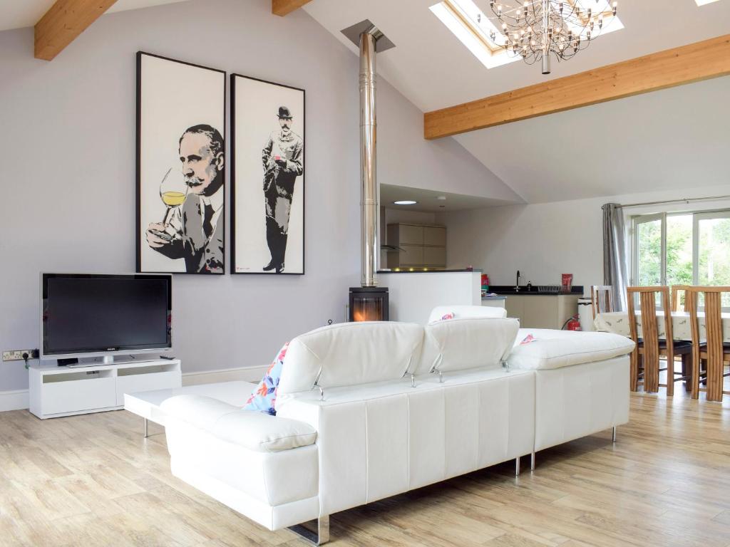 a living room with a white couch and a tv at Lovells Barn in Welland