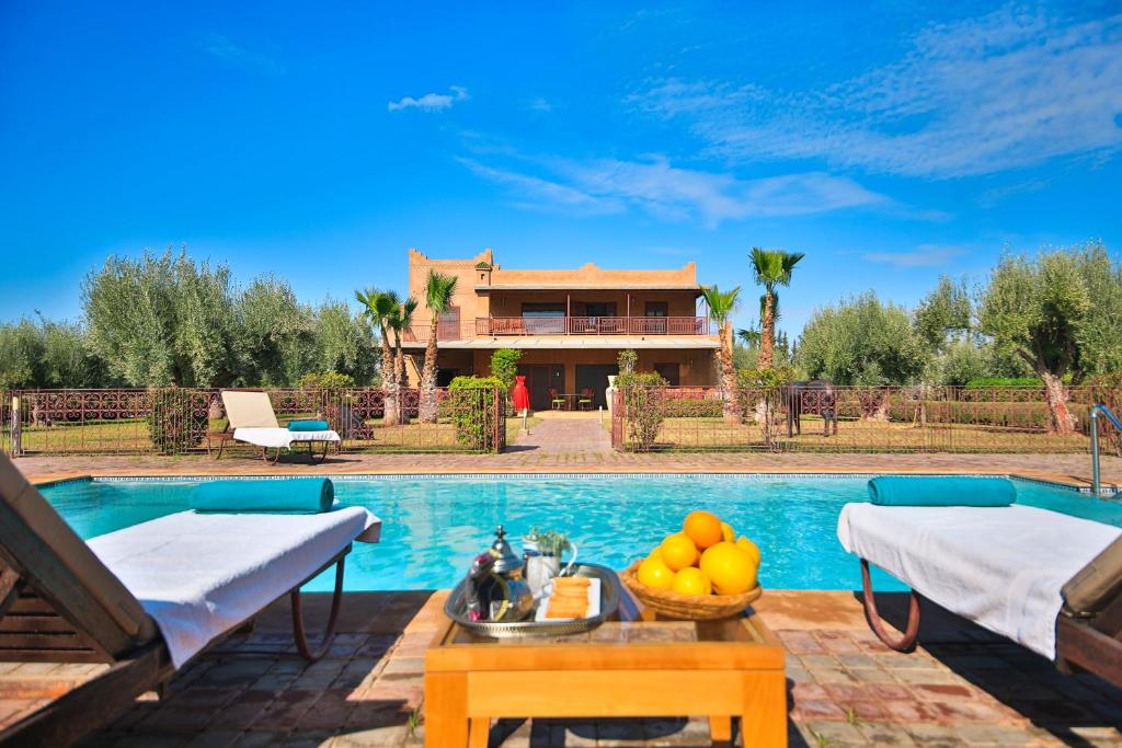 a villa with a swimming pool and a house at Maison safou in Marrakesh