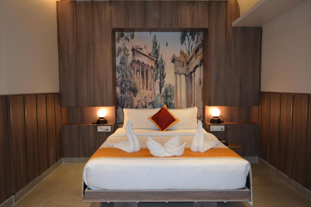 a bedroom with a bed with a painting on the wall at Hotel Muthahalli Grand in Bangalore
