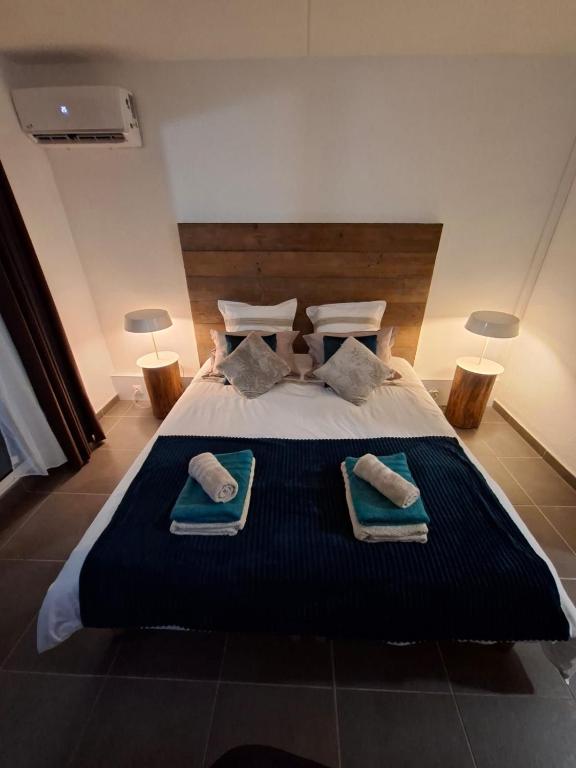 a bedroom with a large bed with towels on it at Kéloué in Saint-François