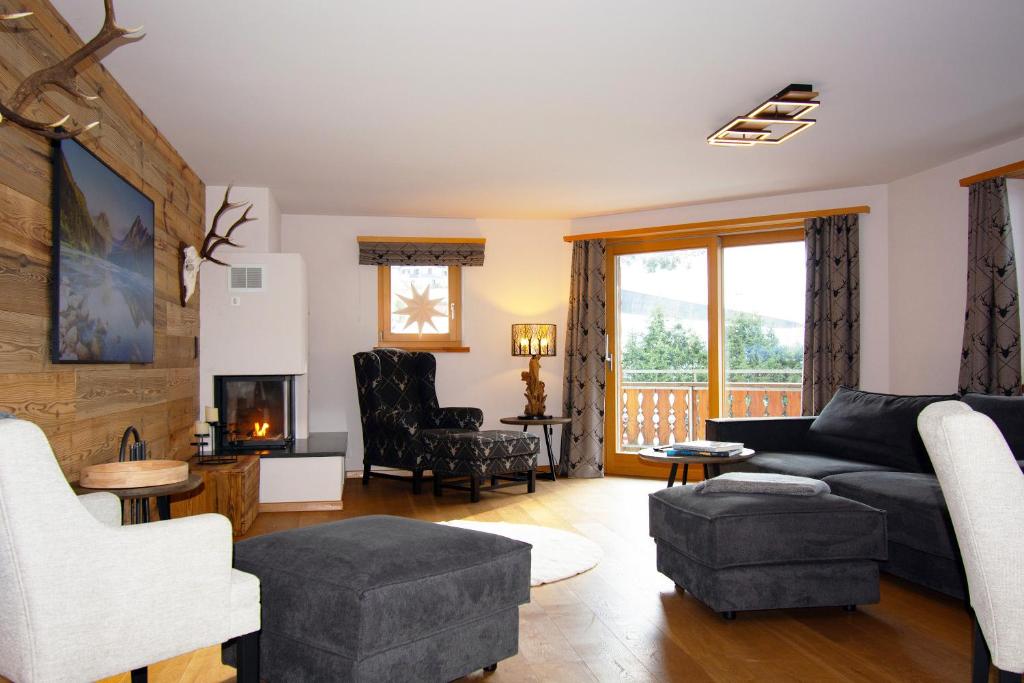 a living room with a couch and a chair at Premium Apartment Grischuna 1-8 Pers in Klosters