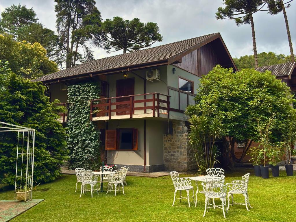a house with tables and chairs in the yard at Casa Garten by Concavus in Campos do Jordão