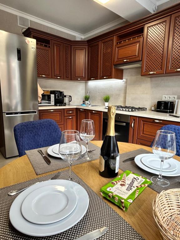a kitchen with a table with glasses and a bottle of wine at Gold in Chişinău