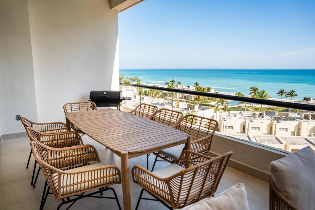 a table and chairs on a balcony with a view of the ocean at Departamento Cadiz in Miramar
