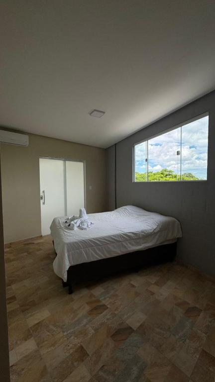 a bedroom with a large bed with a large window at Cantinho dos Pássaros Centro Penedo RJ in Penedo
