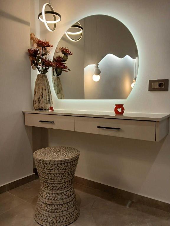 a dressing table with a mirror and a stool at Olympian Gods apartments in Alikanas