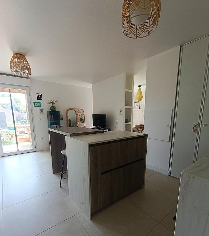a kitchen with a island in the middle of a room at Location cocooning à Audenge in Audenge