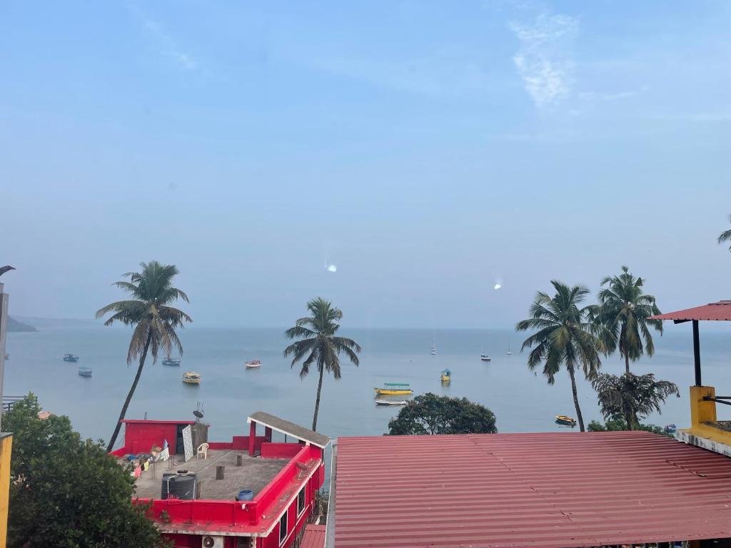 a view of a body of water with palm trees at Vista Maria Guesthouse in Dona Paula