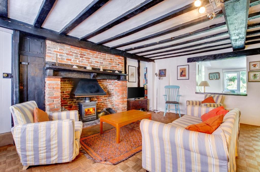 a living room with a brick fireplace and chairs at 2 Bed in Southwold oc-hdanby in Southwold