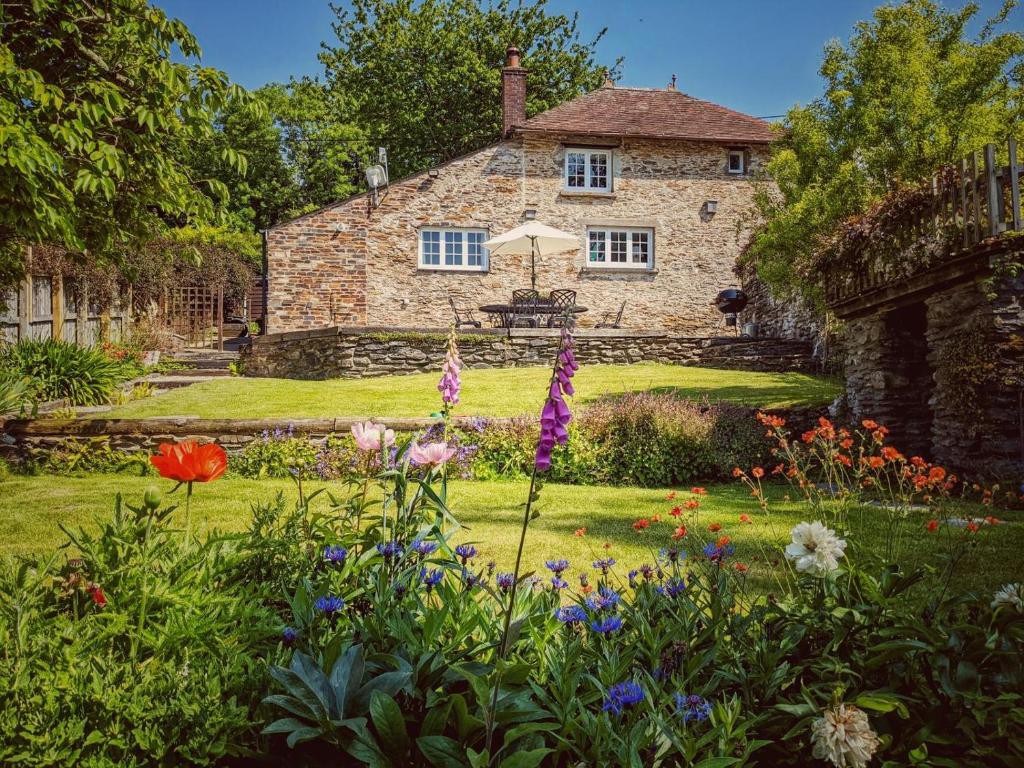 a stone house with a garden in front of it at 3 Bed in Berrynarbor oc-courtc in Berrynarbor