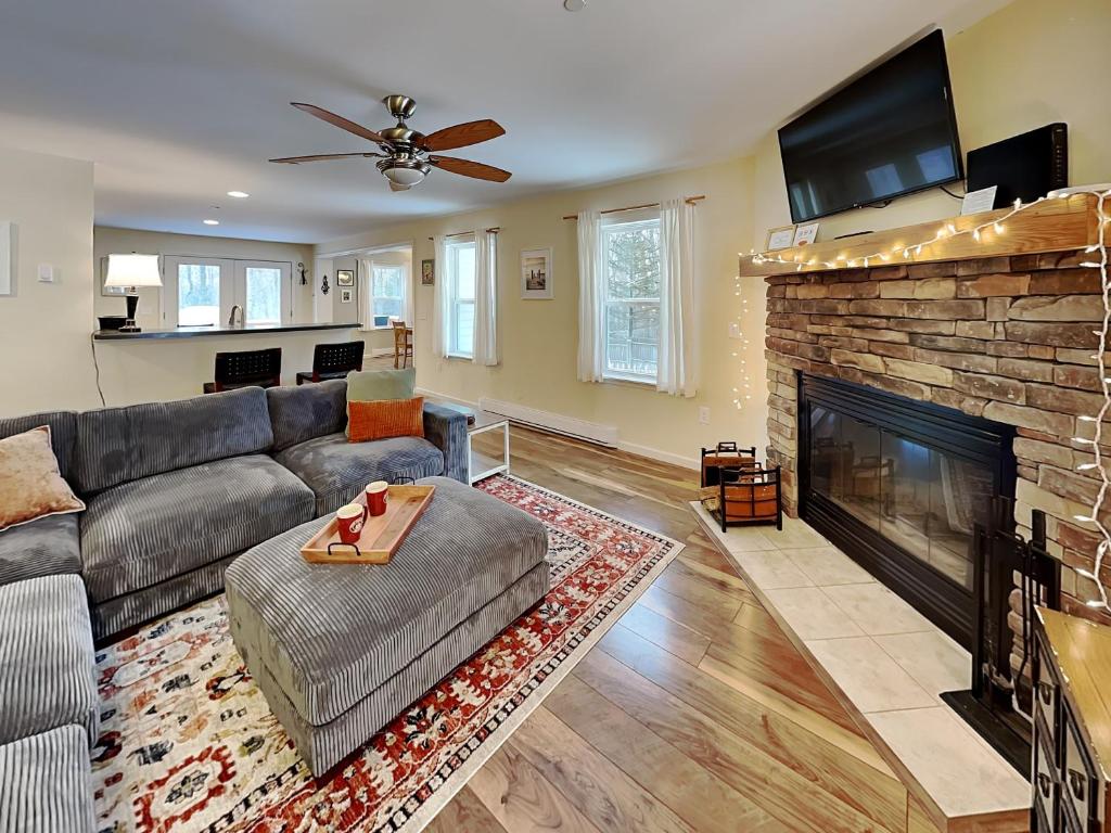 a living room with a couch and a fireplace at The Hideaway House in Swanton