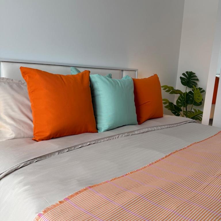 a bed with orange and blue pillows on it at Otopeni Studio C2 3 Airport Therme in Otopeni
